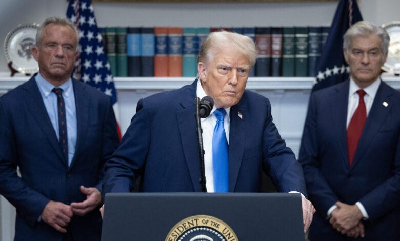 Donald Trump at podium with Robert F. Kennedy Jr. and unidentified man.
