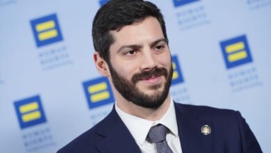 Alex Bores at Human Rights Campaign event, smiling in suit.