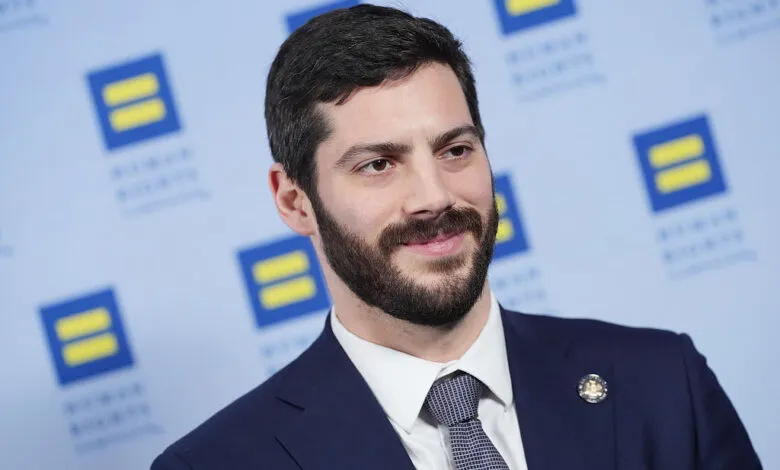 Alex Bores at Human Rights Campaign event, smiling in suit.