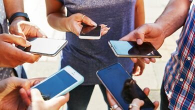 Group of people holding smartphones in a circle formation.