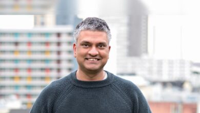 Zain Asgar, Gimlet Labs CEO, smiles in front of city buildings.