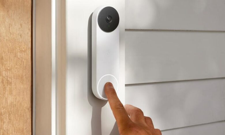 Finger pressing the button on a white Google Nest Doorbell.