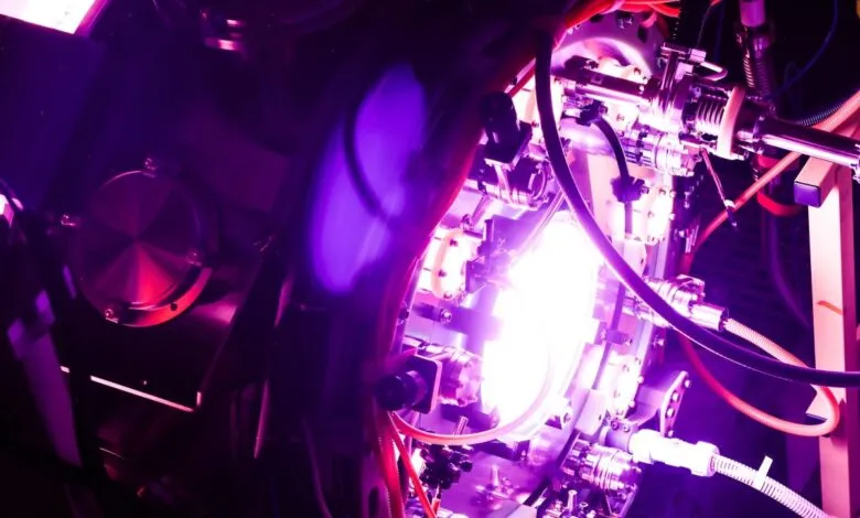 Fusion reactor interior with bright plasma glow and complex machinery.