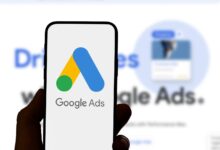Smartphone displays the Google Ads logo in hand.
