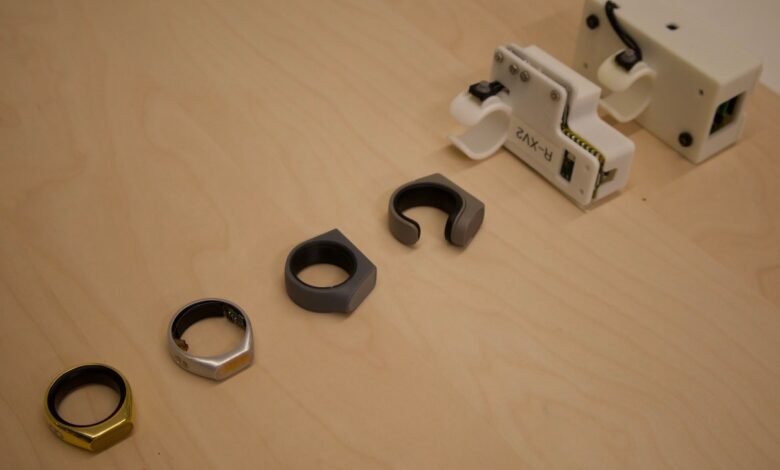 Smart rings and testing equipment on a light wood surface.