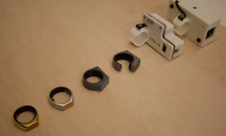 Smart rings and testing equipment on a light wood surface.