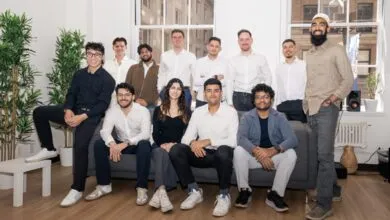 Group of diverse young professionals posing together indoors.