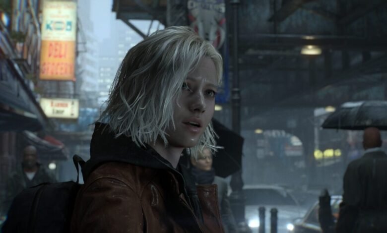 Woman with wet blonde hair in a brown jacket stands on a rainy city street.