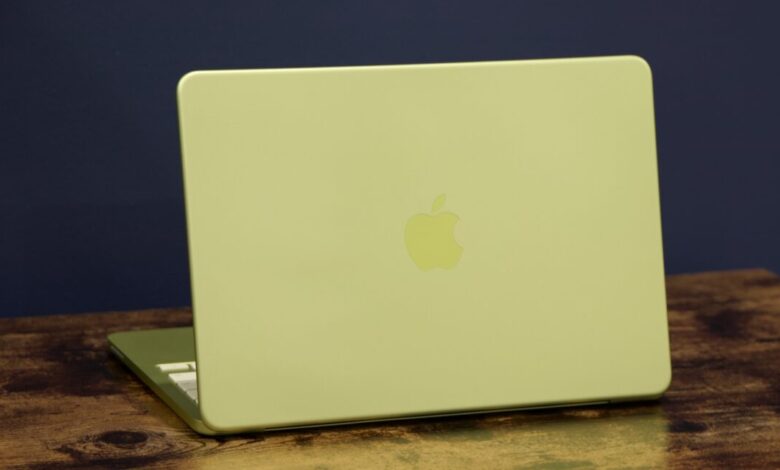 Lime green Apple MacBook laptop on a wooden surface, against a dark blue background.