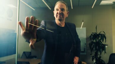 Man in suit presses hand against glass wall in modern office space.
