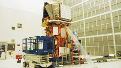 Technicians work on the Swift spacecraft in a clean room environment.
