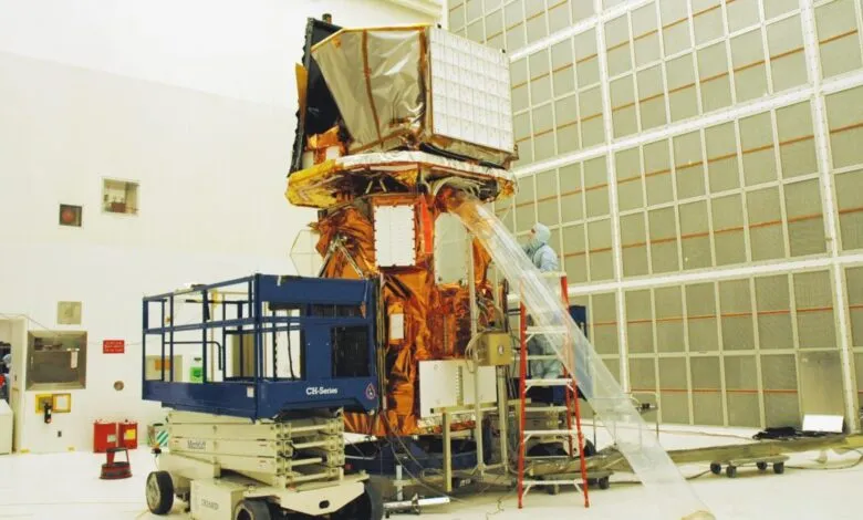 Technicians work on the Swift spacecraft in a clean room environment.