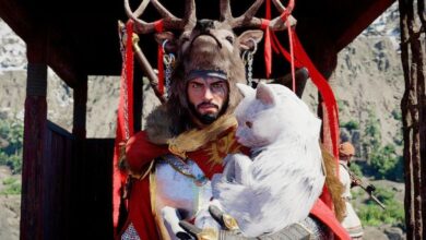 Kliff from Crimson Desert wears stag headdress, holding white cat.