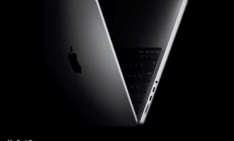 Sleek, partially open MacBook Pro with Apple logo against a dark background.