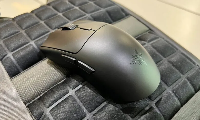 Black Razer mouse sits on a textured gray and black surface.