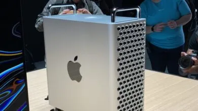 Silver Mac Pro computer with handle and Apple logo on display.
