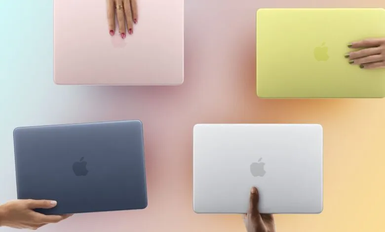 Four colorful MacBook Air laptops held by hands with different skin tones.