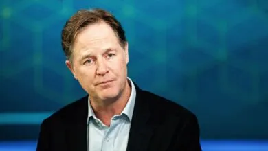 Portrait of Nick Clegg against a blue geometric background.