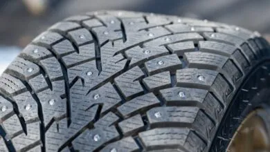 Close-up of a studded winter tire with aggressive tread pattern.