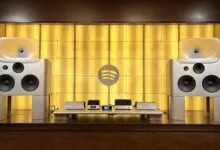 High-end audio system with large speakers and Spotify logo backdrop.