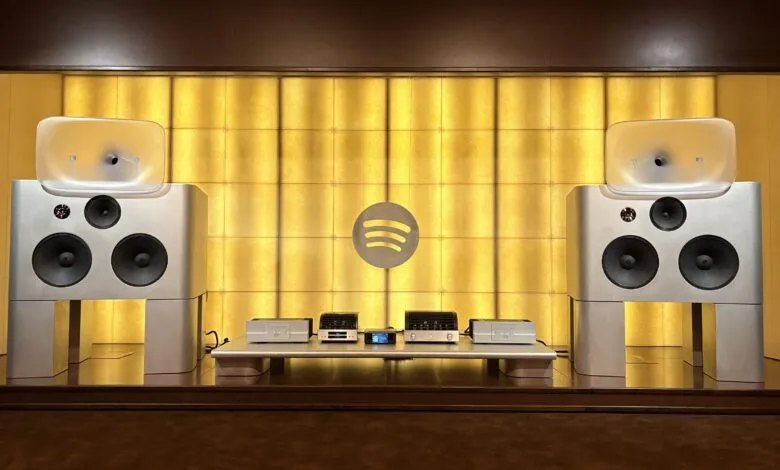 High-end audio system with large speakers and Spotify logo backdrop.