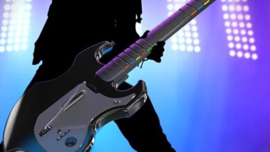 Guitar Hero-style controller with colorful fret buttons and stage lighting.