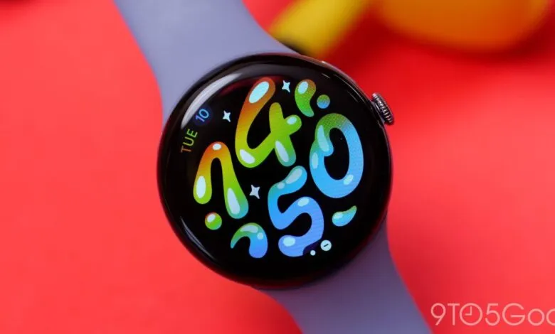 Close-up of a Pixel Watch with a colorful watch face displaying the time.
