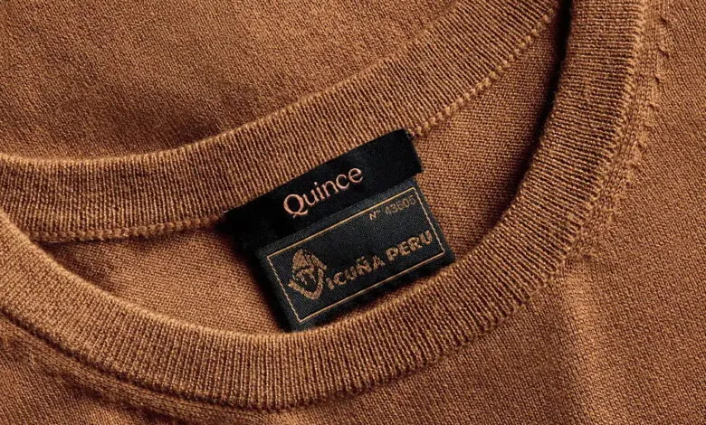 Close-up of a brown Quince sweater with a black label reading 'VICUÑA PERU'.