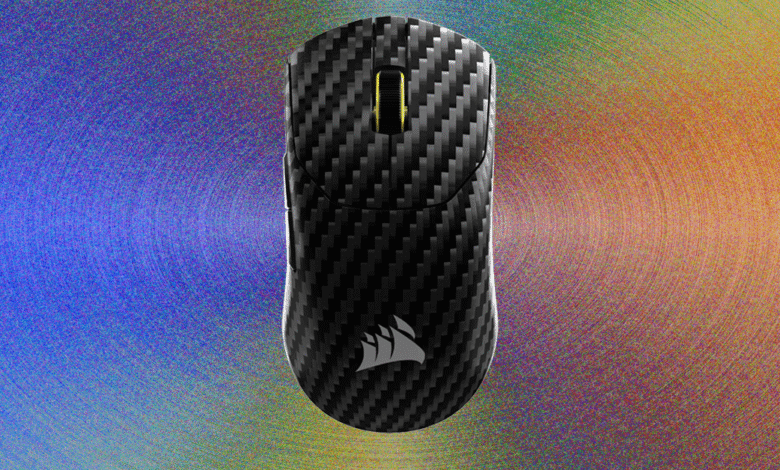 Corsair Sabre V2 gaming mouse with carbon fiber texture on colorful background.