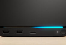 Close-up of a sleek black device with a glowing blue light strip.