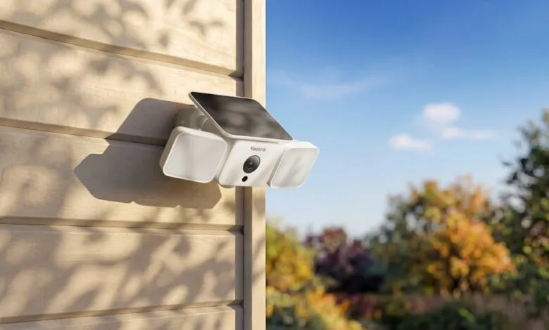 White Reolink security camera with solar panel mounted on a beige wall.