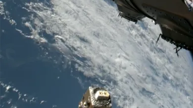 Satellite deploying from spacecraft with Earth visible in the background.