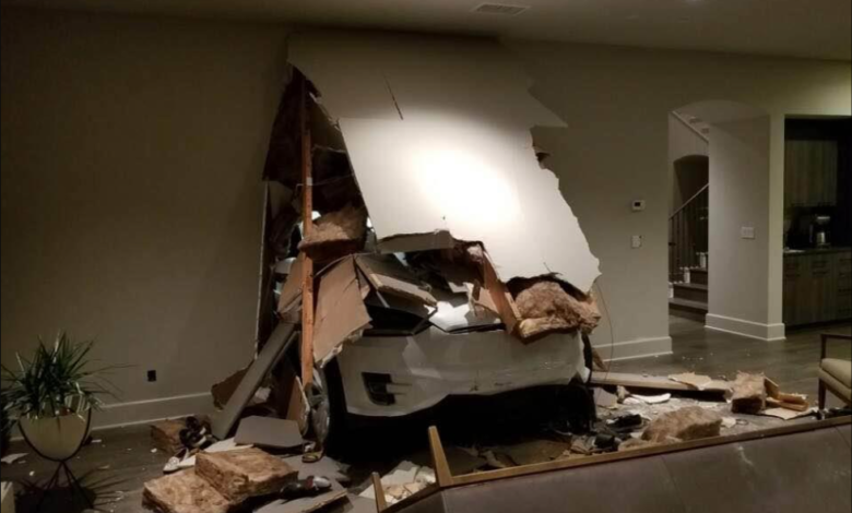 White car crashed through living room wall, causing significant damage.