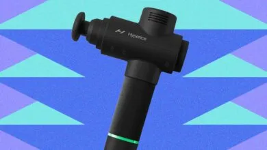 Black Hyperice massage gun against a blue and teal geometric background.