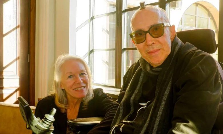 Galen and Deborah Buckwalter pose indoors by a window.