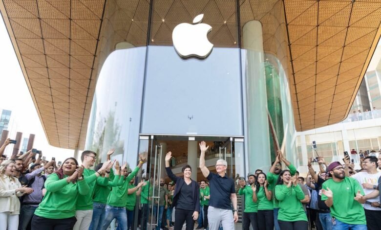 Tim Cook and Deirdre O'Brien wave at Apple BKC store opening.
