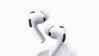 Close-up of white Apple AirPods Pro and charging case on white background.