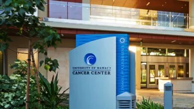 University of Hawai'i Cancer Center sign with building entrance in background.
