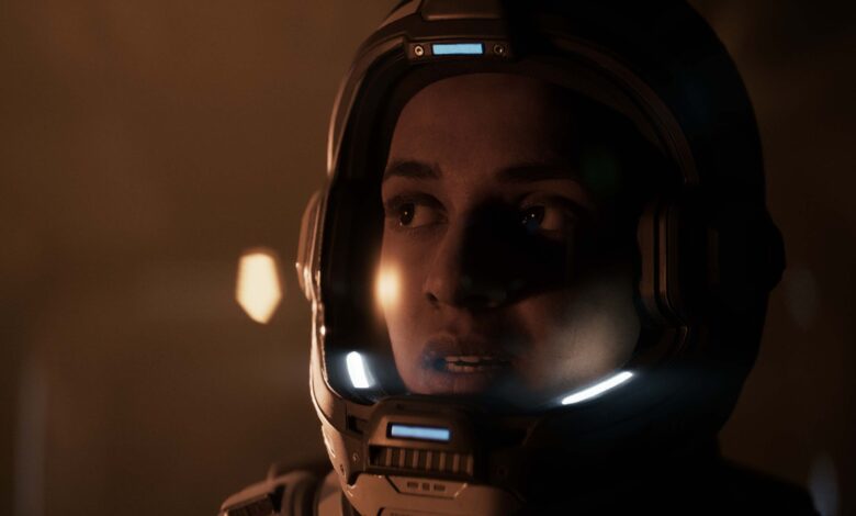 Close-up of a person in a futuristic astronaut helmet looking to the side.