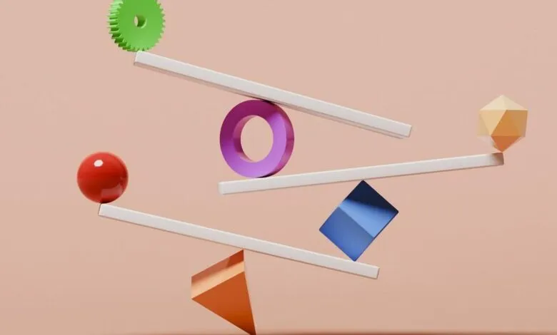 Abstract balance of colorful shapes on white levers against a peach background.