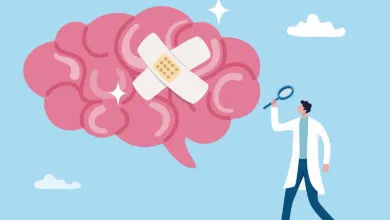 Cartoon brain with bandage being examined by doctor with magnifying glass.