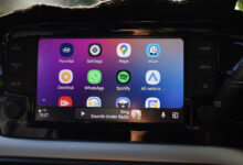 Car dashboard display showing Android Auto home screen with app icons.