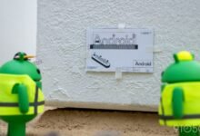 Two Android figures inspect a blueprint of the Android logo.