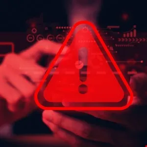 Red warning triangle with exclamation point overlaying hands holding a phone.