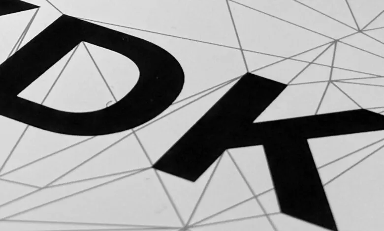 Close-up of 'XDK' in bold black letters against a geometric line pattern.