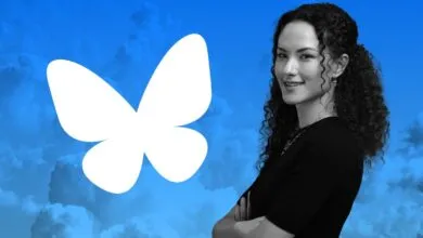 Woman with curly hair stands next to the Bluesky butterfly logo.
