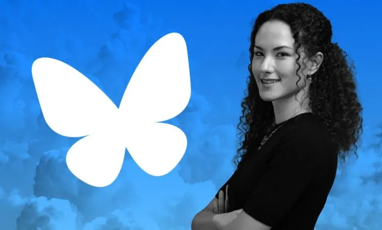 Woman with curly hair stands next to the Bluesky butterfly logo.