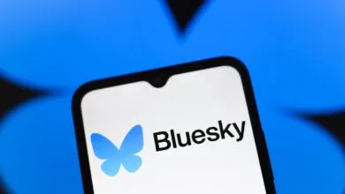 Bluesky app logo on a smartphone screen against a blue background.