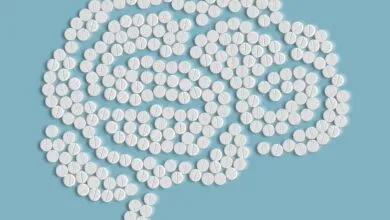 Brain shape formed by white pills on a light blue background.