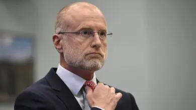 FCC Chairman Brendan Carr adjusts his tie during a hearing.
